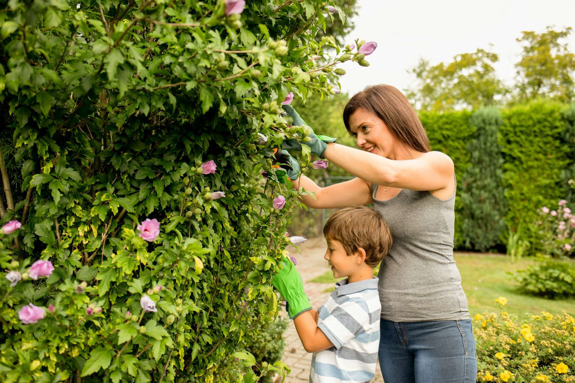 Mom and son taking care of plants in family garden